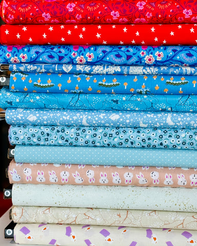 Stack of colorful fabric rolls with various patterns