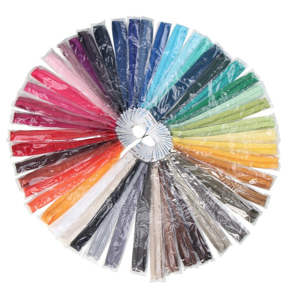 Assorted colorful zippers arranged in a circular pattern on a white background