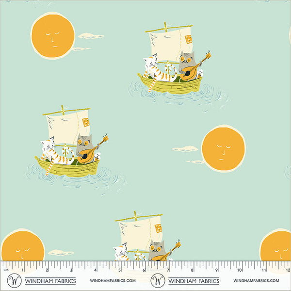 A repeating fabric pattern featuring cartoon cats in small sailboats with guitars, yellow suns, and small white clouds on a pale mint background. A ruler at the bottom shows scale and includes the text Windham Fabrics and the website windhamfabrics.