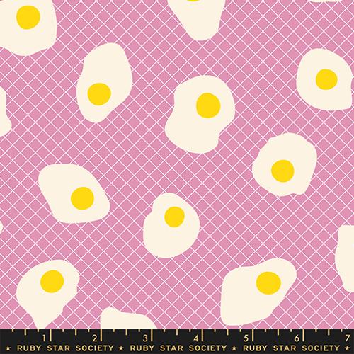 Pattern of fried eggs with yellow yolks on a pink background with a grid, branded 'Ruby Star Society'.