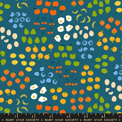 Fabric pattern with colorful fruits and vegetables on a blue background, featuring the Ruby Star Society label.