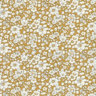 A close-up of a floral patterned fabric or wallpaper featuring small white flowers with gray centers on a mustard yellow background.