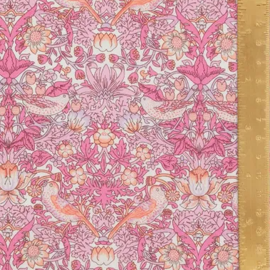 Pink floral and bird patterned fabric with a ruler on the right side.