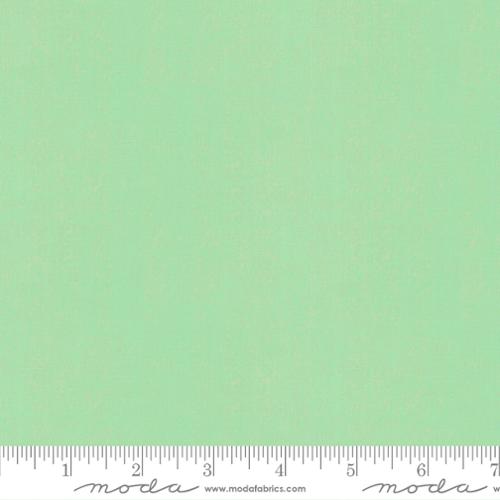 Solid light green fabric swatch with a ruler at the bottom