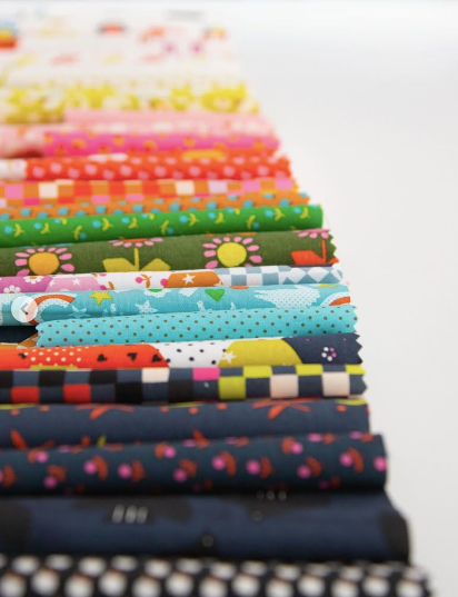 Stack of colorful fabric bundles on a white background