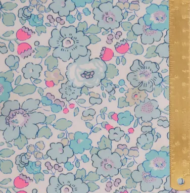 Floral patterned fabric with a ruler for scale on a gold background