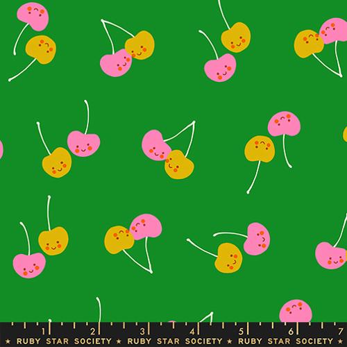 Pattern of colorful cherries on a green background with a ruler at the bottom.