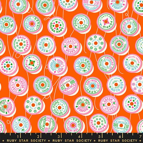 Fabric with colorful spool pattern on an orange background, featuring Ruby Star Society label.