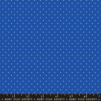 A close-up fabric pattern swatch showing a royal blue background with a repeating small white star motif. A dark ruler strip along the bottom edge reads Ruby Star Society.