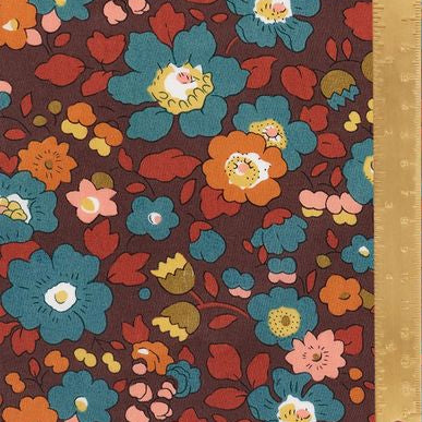 Floral fabric pattern with a ruler for scale on a brown background